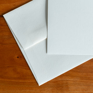 Close up of textured cotton fine art paper and natural white cotton envelope